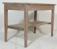 An early 20th century scrubbed top oak side / console table being raised on square tapering block