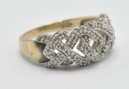 A hallmarked 9ct gold pierced knot design ring being illusion set with diamond accent stones.