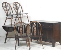 A contemporary 20th century Ercol Furniture beech and elm wood dining room suite comprising a drop