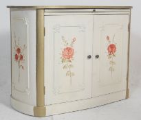 A  mid century shabby chic painted lozenge shaped French commode cupboard. The cupboard with twin