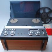 A vintage Revox A77 reel to reel stereo tape recorder having teak wood case, dark perspex dust cover