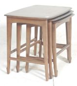 A mid century retro  Danish inspired teak wood nest of tables. The tables being raised on squared,