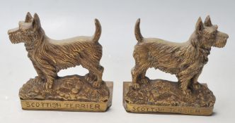 A pair of early 20th Century brass bookends in the shape of a Scottish Terrier. The bookends have