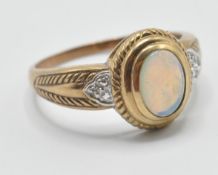 A 9ct gold 20th Century ring set with an oval cabochon bezel set in a stepped mount flanked with two