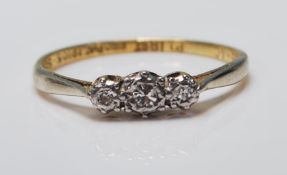 A mid Century 18ct gold and platinum ring being set with three white stones in platinum settings.