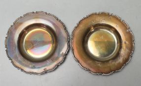 A pair of silver hallmarked small pin dishes of round form having scrolled shaped and raised borders
