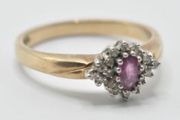 A hallmarked 9ct gold ladies ring being set with a central oval cut ruby surrounded by round cut
