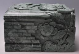 A large 20th Century Chinese table top green stone lidded box of rectangular form being carved