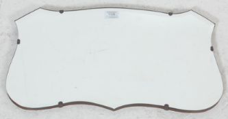 A 1920’s vintage wall hanging mirror in a shape of a shield with beveled glass mirror, oak back