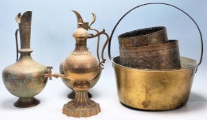 A pair of Indian brass ewer jugs having bulbous tapering bodies raised on footed bases with cobra