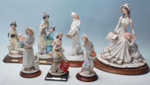 Auro Belcari - A collection of 7 china figurines by Belcari to include a boy collecting fruit, a