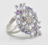A large 925 silver CZ dress ring with multicolour stones set in a floral arrangement. Size P,