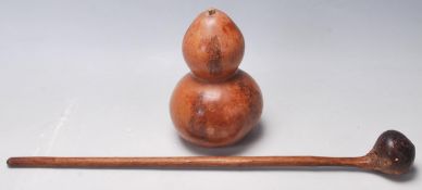 An early 20th century tribal hand carved Knobkerrie weapon along with a double gourd vase with