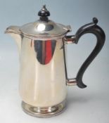 An early 20th century, 1912 silver coffee pot of cylindrical form with sparrow-beak spout, ebony