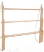 A Victorian 19th century country pine delft rack of shaped construction being wall mounted with