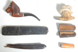 A collection of 20th century antique smoking pipes to include hand carved German black forest pipe