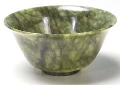 A 20th Century Chinese carved green stone footed bowl of small proportions having a flared rim.