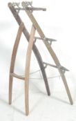An antique early 20th Century brass and wooden ladder of unusual form using a repurposed middle