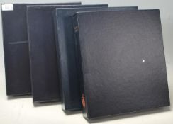 A large collection of 20th Century British stamps within a set of four leather bound presentation