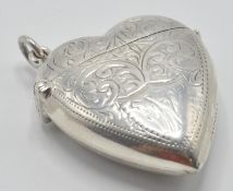 A sterling silver vesta case in the form of a heart with having a chased decoration. Marked