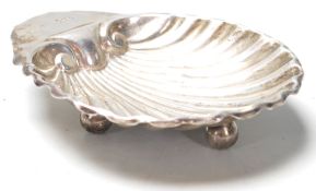 A silver hallmarked Daniel George Collins trinket dish in the form of a scallop shell raised on