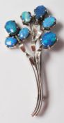 A mid 20th Century silver floral spray brooch being set with seven oval opal doublets in prong