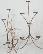 A pair of vintage 20th century retro blacksmith iron florist plant stands being made of metal band