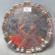 An antique Edwardian hallmarked sterling silver salver plate having pie crust edges and raised on