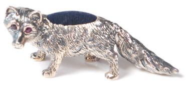 A STERLING SILVER PIN CUSHION IN THE FORM OF A FOX.