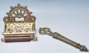 A PAIR OF ANTIQUE BRASS SEWING SCISSORS, TOGETHER WITH A BRASS TOILET ROLL HOLDER.