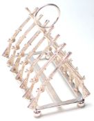 A SILVER PLATED TOAST RACK FORMED FROM CROSSED RIFLES.