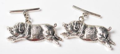A PAIR OF STAMPED STERLING SILVER CUFFLINKS IN THE FORM OF TWO PIGS.