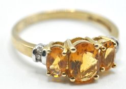 9CT GOLD RING SET WITH THREE OVAL CUT ORANGE STONES