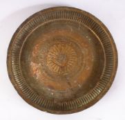 A 19TH CENTURY INDAIN BRASS CHARGER / DISH, with embossed decoration, 22.5cm.