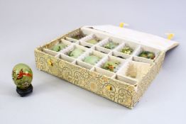 A LOT OF TEN CHINESE CARVED AND PAINTED JADE EGGS, presented in a silk lined box, eggs approx 4cm