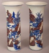 A PAIR OF CHINESE COPPER-RED & UNDERGLAZE-BLUE CYLINDRICAL PORCELAIN VASES, each decorated with a