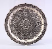 A CHINESE WHITE METAL DRAGON DISH, decorated with many dragons amongst clouds, 12cm.