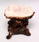 A GOOD CHINESE ROSE QUARTZ TOPPED LOW TABLE, the base formed from naturalistically carved wood