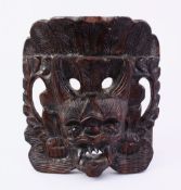 AN ORIENTAL CARVED HARDWOOD MASK, 13CM