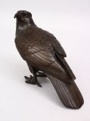A JAPANESE MEIJI PERIOD BRONZE OKIMONO OF A HAWK, the hawk looking back, 6cm high x 21cm wide.
