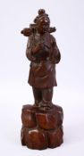A JAPANESE MEIJI PERIOD CARVED WOODEN OKIMONO OF A TRAVELLING BOY, the boy wearing his pack pack and