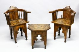 A 19TH CENTURY MOORISH INLAID WOODEN PAIR OF ARM CHAIRS AND TABLE, inlaid with a multitude of