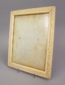 A LARGE 18TH / 19TH CENTURY INDIAN CARVED IVORY FRAME, with decorated bands of formal scroll, 30cm x