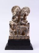 A GOOD GHANDARA CARVED STONE FIGURE, of two figures with an animal, 22cm high on stand.