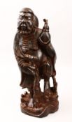A LARGE 19TH / 20TH CENTURY CHINESE CARVED HARDWOOD FIGURE OF AN IMMORTAL, possibly carved from