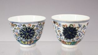 A GOOD PAIR OF CHINESE DOUCAI PORCELAIN CUPS, each decorated with scenes of formall lotus foliage,