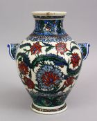 A GOOD 19TH CENTURY TURKISH POTTERY FLORAL DECORATED TWIN HANDLE VASE, the base signed, 24cm.