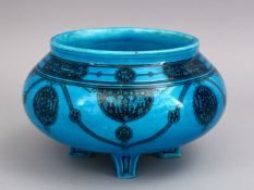 A GOOD KASHAN TURQUOISE POTTERY BOWL, stood on four feet, with black painted decoration of