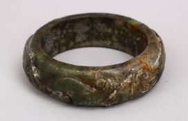 A CHINESE CARVED JADE BANGLE, carved in archaic form, 9cm