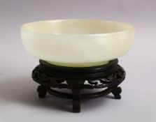A FINE QUALITY CHINESE CARVED WHITE / CELADON JADE BOWL & STAND, the bowl finely carved, fitted with